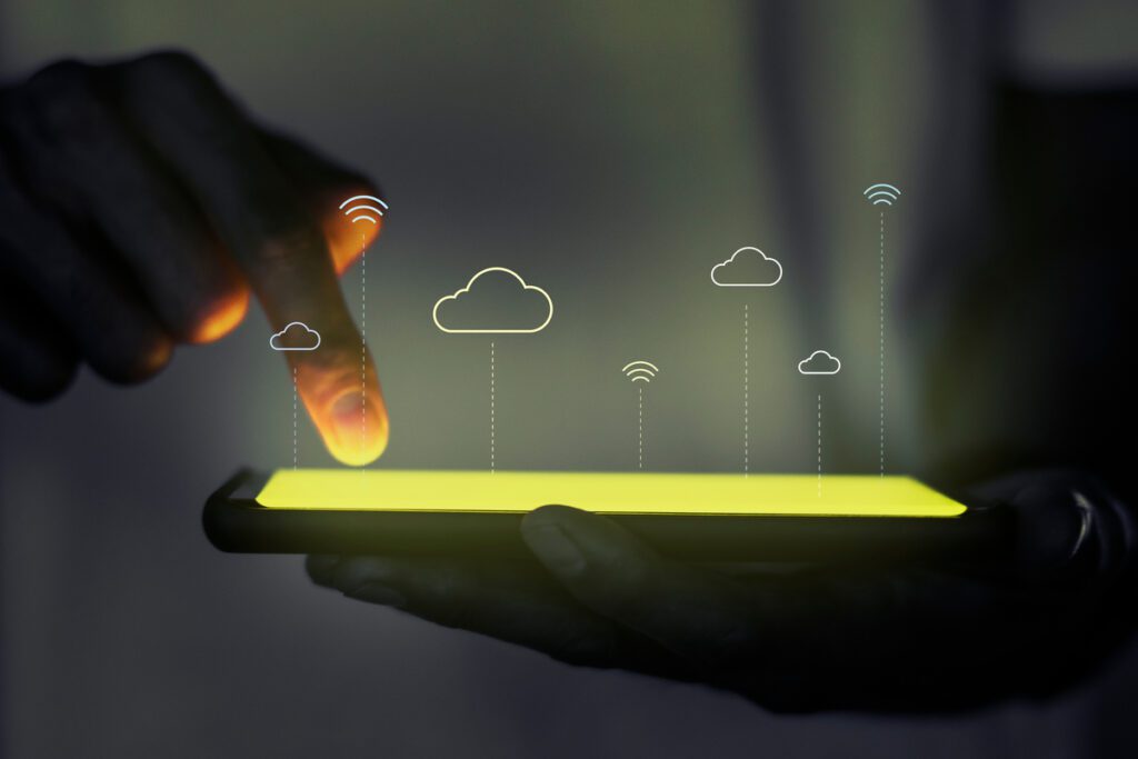 A person using a tablet with projected cloud network icons